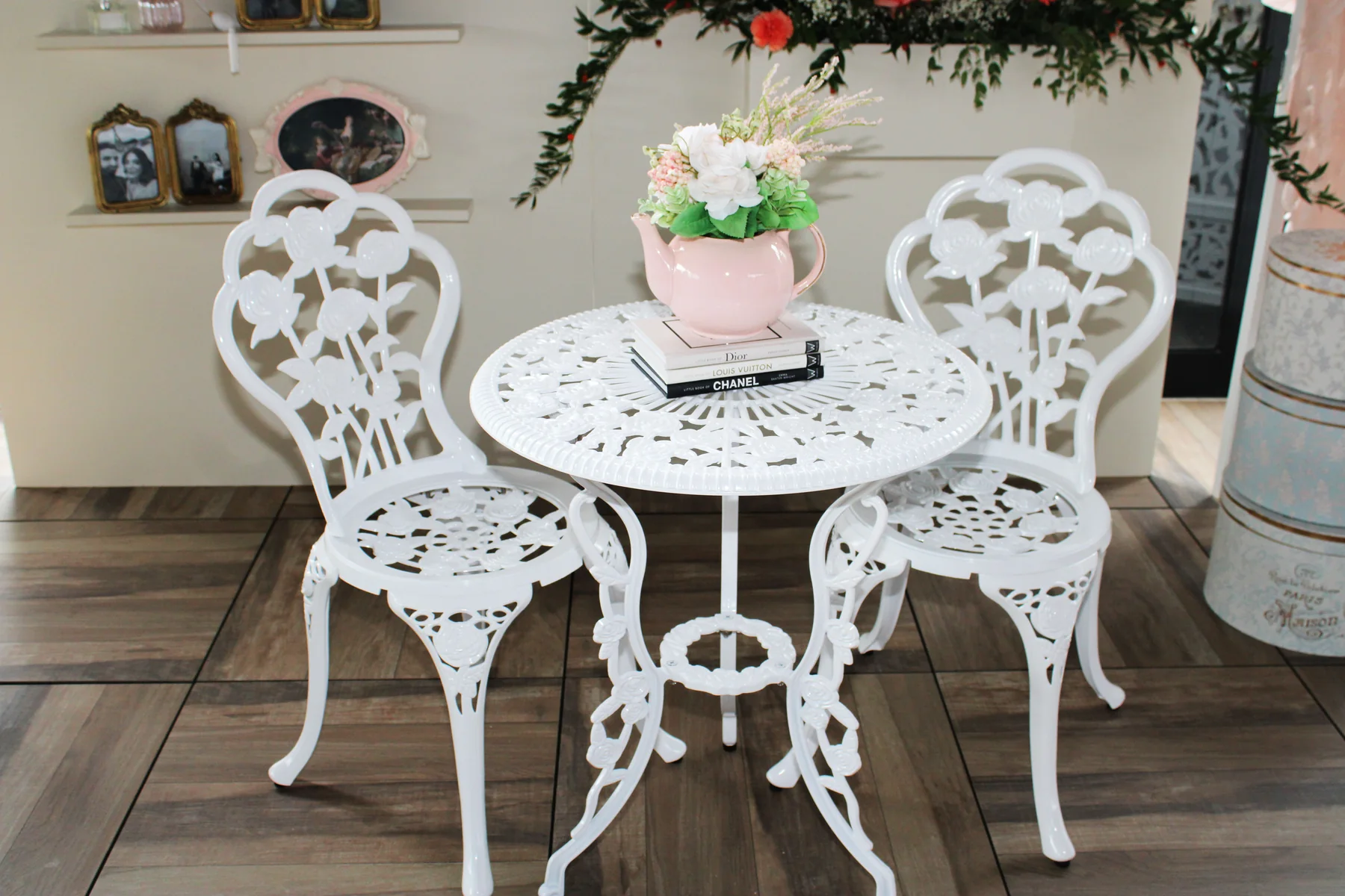 Parisian-inspired event styling vignette with white bistro table, floral arrangement, and decor details