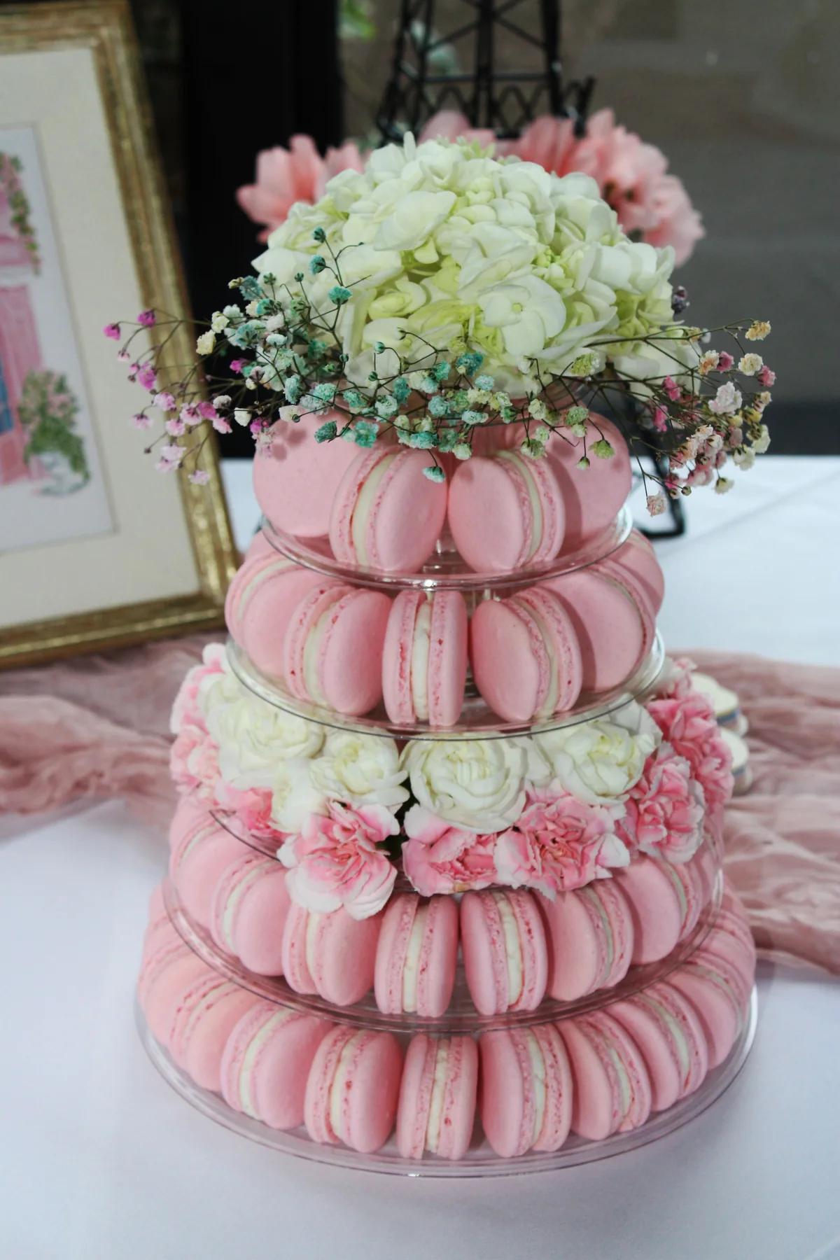 Pink macaron tower with florals for French themed bridal shower